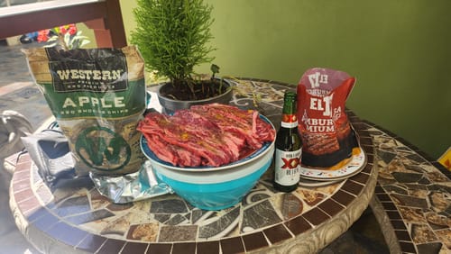 Empaque de Hamburguesa Premium del cliente en una mesa, junto a carne cruda y otros artículos para parrillada.