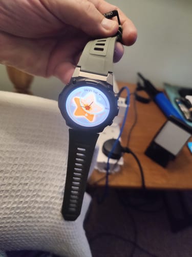 Customer holding their Gard Pro Ultra 3 smartwatch, showing the green strap and illuminated screen.