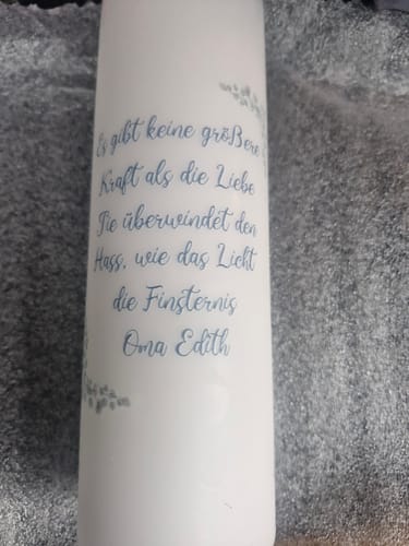 Kundenbild einer personalisierten weißen Kerze mit blauem Text nach dem Datencheck.