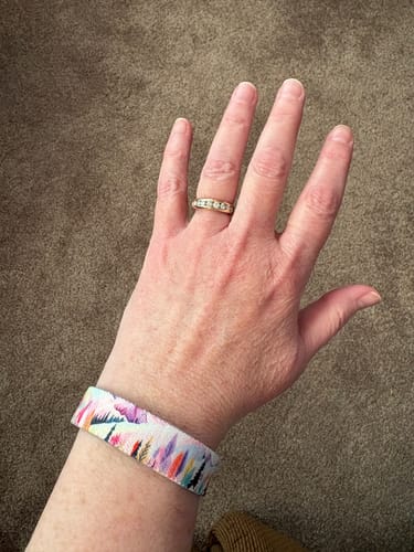 Customer showing the fit of their colorful 'You Deserve Happiness' bracelet on their wrist.