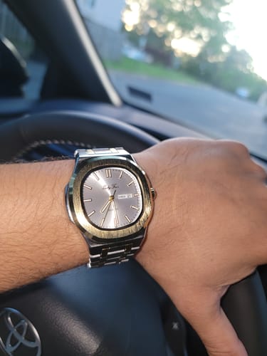 Customer wearing their two-tone Lucky Fours® Brone watch on their wrist while in a car.
