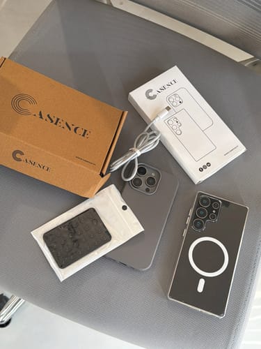 Reviewer displays the clear Magsafe Samsung case on a phone, next to its packaging and a free charging cable.