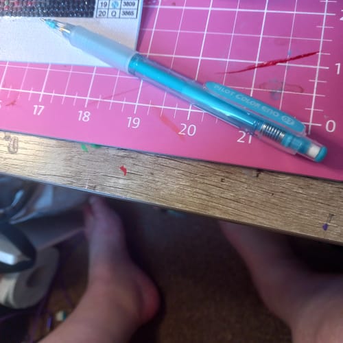 Customer's pale blue Pilot Color Eno pencil resting on a pink gridded craft mat.