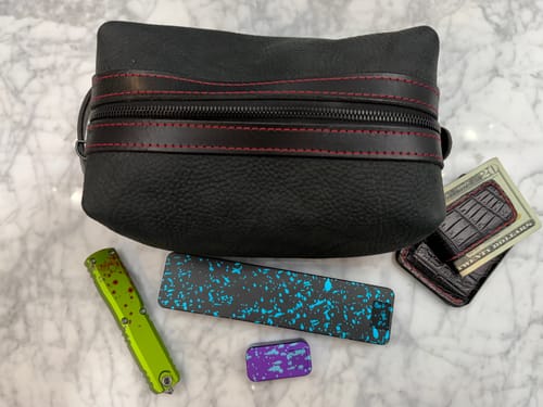 Customer's two colorful Weekly Case pill cases displayed with other everyday carry items on a marble surface.