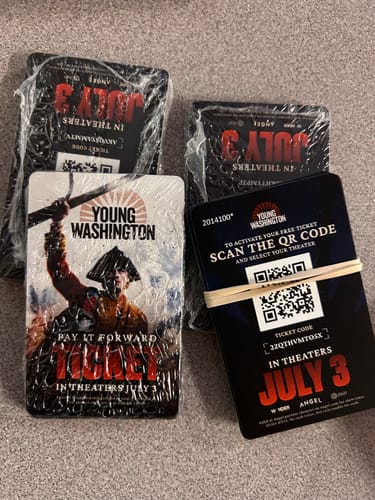 Reviewer showing the Young Washington Classroom PIF Packs, which are stacks of movie tickets for students.