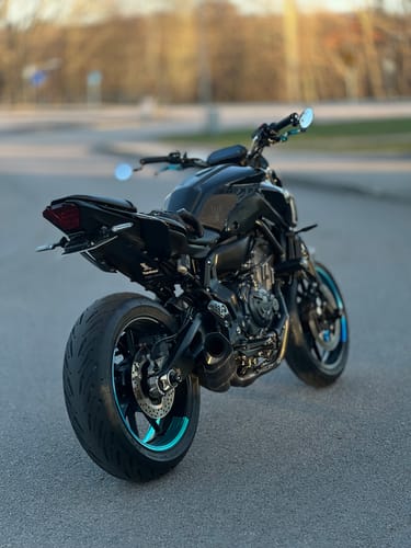 Customer's black motorcycle from the rear, showing the universal Plate Light installed above the license plate.