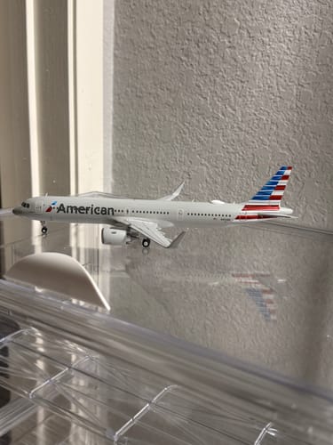 Customer's GEMINI200 AMERICAN A321NEO model airplane shown from the side in a clear display case.