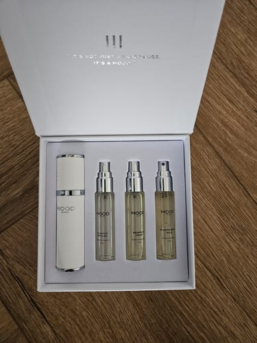 Customer's Spray Box Set open, showing a white travel case and three small fragrance refills in a presentation box.