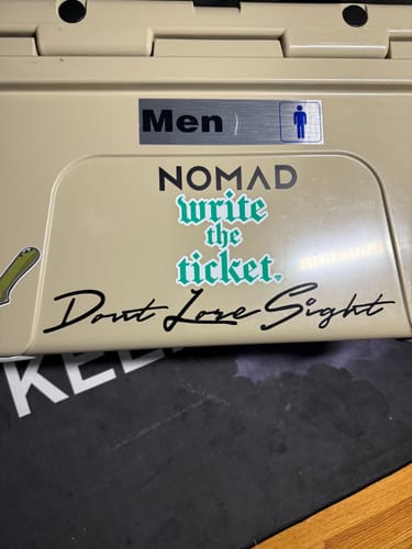 Customer's 'Write the Ticket Decal' applied to a beige cooler next to other stickers.