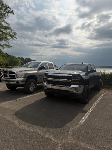 Customer's black Chevy Silverado 1500 with a leveled stance after installing the front lift kit, parked in a lot.