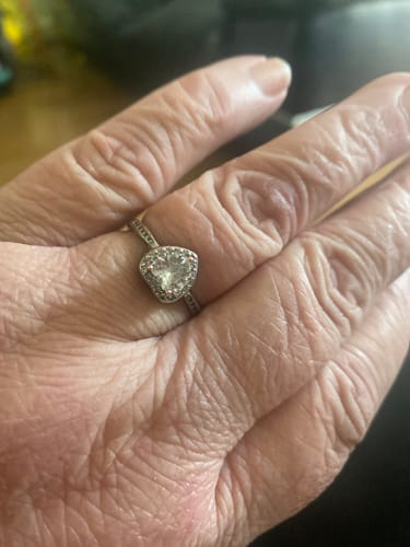 A reviewer's hand wearing the silver, heart-shaped Forever In My Heart Urn Ring.