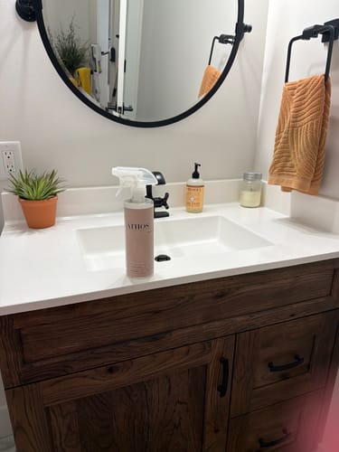 Reviewer's orange towel hanging next to a shiny bathroom sink.