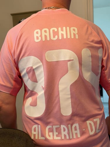 Client montrant le dos de son maillot rose de l'Algérie avec un flocage personnalisé.