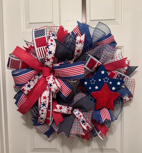 Customer's patriotic wreath made with the Faux Jute Check Mesh, decorated with red, white, and blue ribbons and star accents.