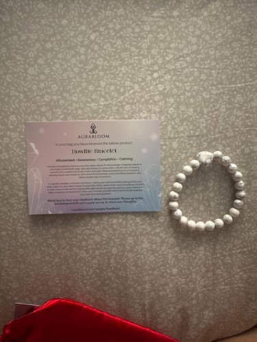 Customer's white Howlite bead bracelet from the VIP Crystal Club, shown with its product card.