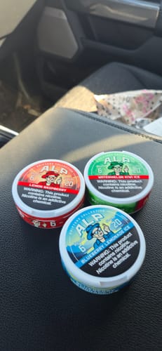 Customer's tin of Drifters Lemon Raspberry Nicotine Pouches next to two other new flavors on a car console.
