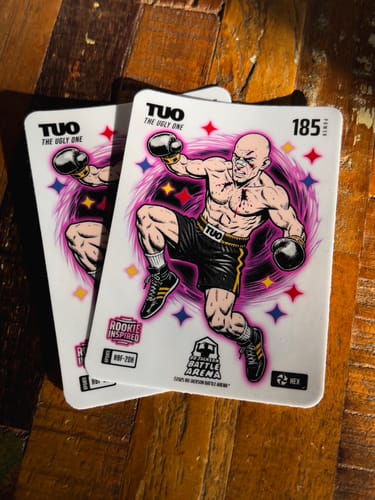Customer's Cut to Shape Stickers with a cartoon boxer design, shaped like rectangular trading cards on a wooden surface.