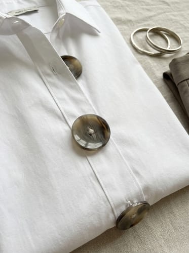 Customer's close-up of the white lapel blouse, showcasing the large, marbled buttons.