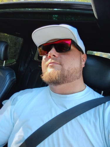 Customer wearing the white Big Flat Bill Structured Canvas Hat while sitting in a car.