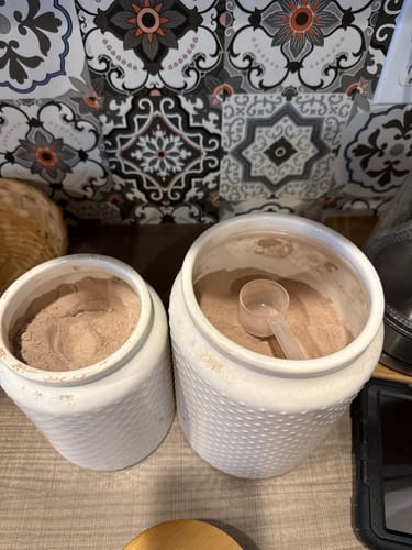 Customer's Perk Chill powder in two white textured canisters, one with a scoop.