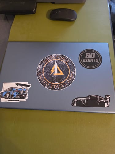 A customer's blue laptop decorated with several automotive stickers from the 80Eighty® DCG87 Sticker Pack.