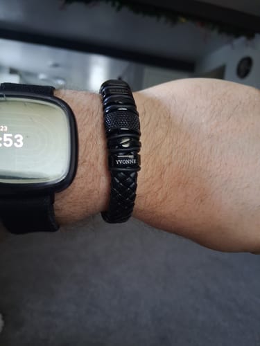 Customer wearing the personalized black bracelet on their wrist next to a watch.