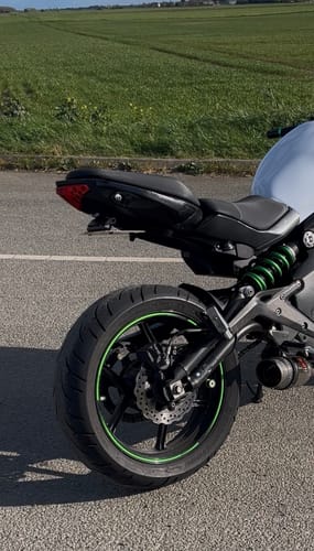 A reviewer's Kawasaki ER6N motorcycle with a sleek tail tidy installed, showing the clean rear profile.