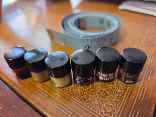 Reviewer's Bestsellers Set of 1ml perfume samples lined up next to a measuring tape to show their small size.
