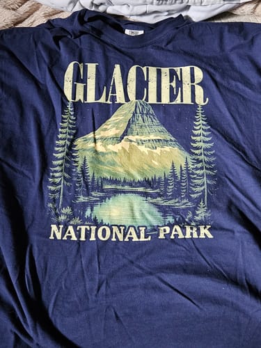 Customer's dark blue Glacier National Park t-shirt laid flat, showing the Bearhat Mountain graphic.