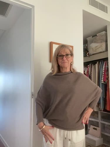 A customer wearing the mink Asymmetric Draped top, which has a loose and comfortable fit.