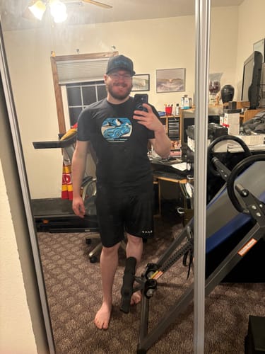 Customer taking a mirror selfie while wearing the black 80Eighty® Summit Speed Shirt in a room.