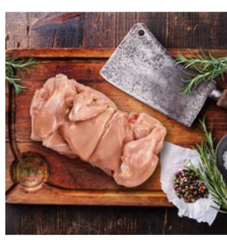 Customer's raw Halal chicken pieces on a wooden board with a meat cleaver and herbs.