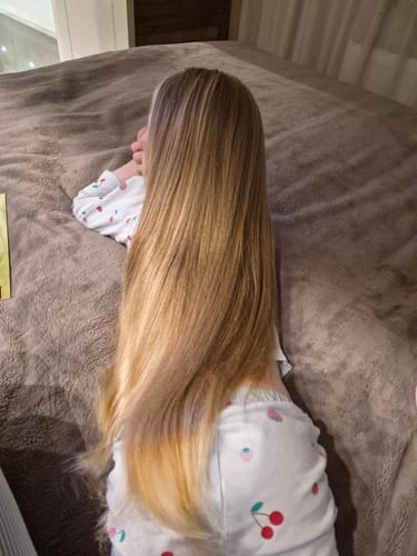 Customer showing the results on long, smooth hair after using OI All In One Milk.