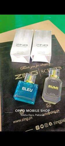 Customer's unboxed Bleu and Rumi perfumes displayed in front of their white packaging boxes.