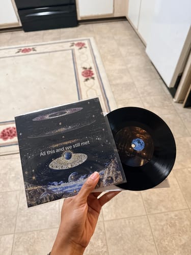 Customer holding their new Custom Vinyl Record and personalized sleeve with galaxy artwork.