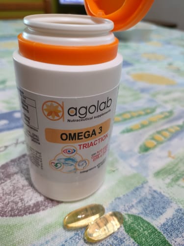 Recensione cliente del flacone di Omega 3 aperto, con due capsule in primo piano.