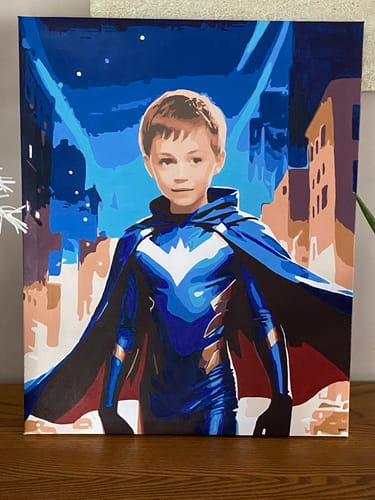Customer's finished painting from the Night City Hero kit, showing a young superhero in a blue costume before a city at night.