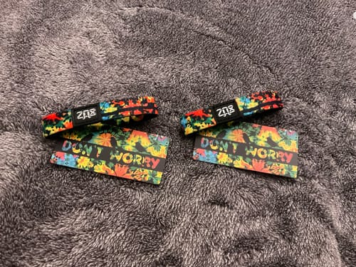Customer's two colorful Don't Worry Bracelets with matching 'DON'T WORRY' cards on a fuzzy grey surface.