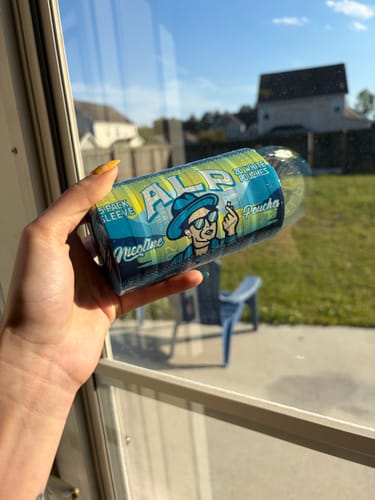 Customer holding a sleeve of Drifters Blueberry Lemonade Ice Nicotine Pouches outdoors on a sunny day.
