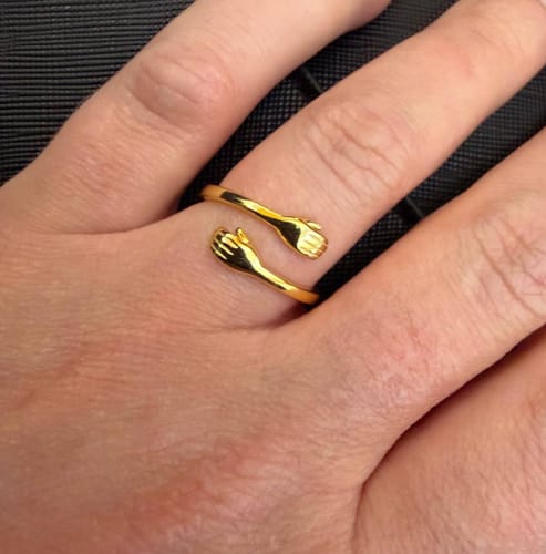 Reviewer's hand wearing the gold-plated Embrace Ring.