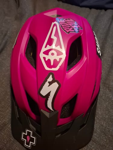 Customer's logo transfer decals applied to the top of a pink and black bike helmet.