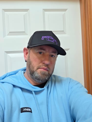 Customer taking a selfie wearing the black 80Eighty® Limited Edition DCG88 Hat with a purple car outline on the front.