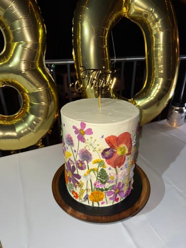 Customer's beautiful cake decorated with colorful Pressed Flowers for a birthday celebration.