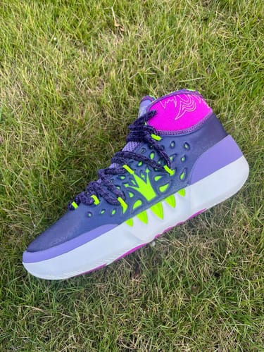 Reviewer's Joker 2 'Joker' High basketball shoe in a purple, green, and pink colorway, shown from the side on grass.