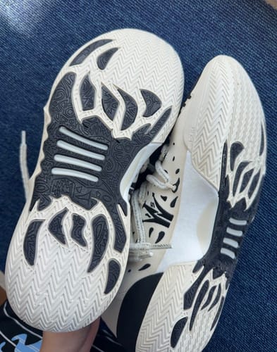Reviewer showing the detailed white and black outsoles of the Joker 2 "Ace" High basketball shoes.