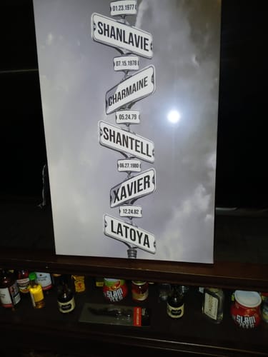 Reviewer's photo of their undamaged gift, a custom canvas showing street signs with names and dates.