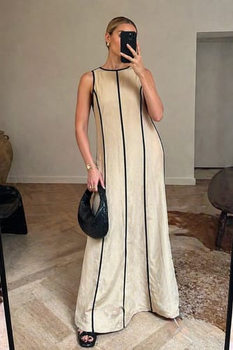 Reviewer in a mirror selfie wearing the khaki A-Line Loose Maxi Dress with black contrast lines.
