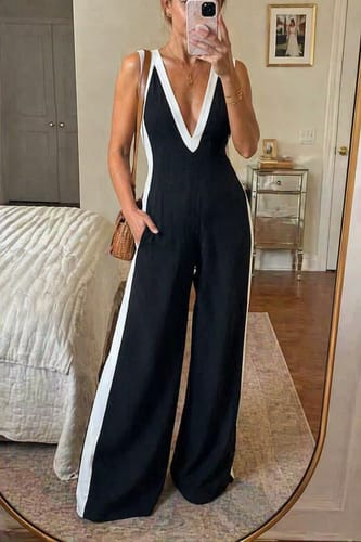 Customer takes a mirror selfie wearing the black and white deep V-neck jumpsuit with wide legs.
