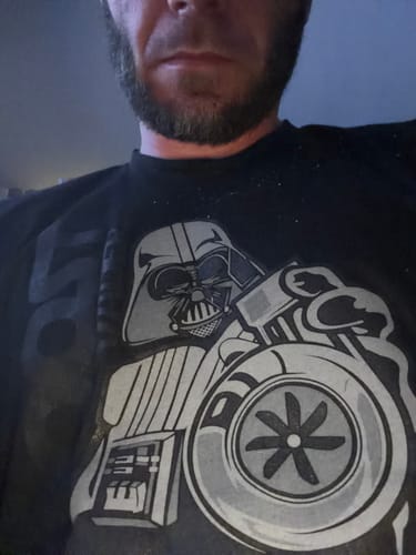 Close-up of a customer wearing the black 80Eighty® Summit Speed Shirt with a character and turbo graphic.