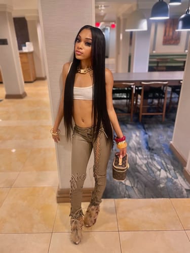 Customer posing in the low-rise, tan Vice Pant, showing the lace-up details on the legs.